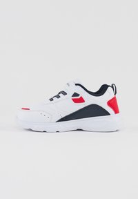 Zapatilla deportiva blanca con acentos negros, detalles rojos y una cubierta texturizada; cuenta con un cuello acolchado y cierre de cordones.
