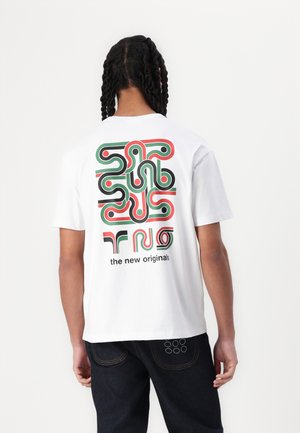 White cotton t-shirt featuring a colorful abstract graphic in red, green, and black on the back, with rounded shapes and text below the design.