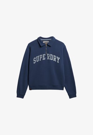 Granatowy polar z kołnierzem, z połową zamka na przodzie oraz napisem "SUPERDRY" w jasnoszarym kolorze na klatce piersiowej. Miękka mieszanka bawełny.