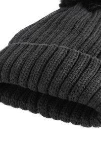 Schwarze, gestrickte Mütze mit Rippstruktur und weichem Bommel oben. Die Textur ist dick und flauschig, sorgt für Wärme.