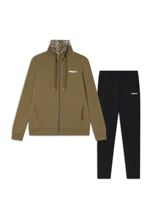 Giacca con zip di colore verde oliva con colletto interno a strisce di tigre, abbinata a pantaloni neri. Entrambi presentano il logo 'FREDDY' in bianco. Materiale misto cotone.
