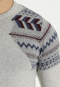 Maglione grigio a maglia con dettagli a motivo in rosso scuro e blu sulle spalle, con scollatura rotonda e polsini a costine.