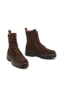 Stivaletti in suede marrone con suola robusta, dotati di lacci sul davanti e cerniera laterale, e di un morbido rivestimento in tessuto.