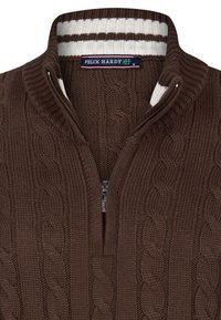 Suéter marrón de punto trenzado con cuello con cremallera, que presenta un forro interior a rayas en blanco y marrón y una etiqueta "Felix Hardy" en el escote.