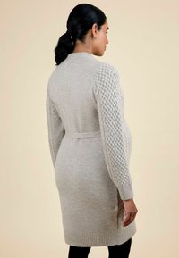 Hellgrauer, gestrickter Cardigan mit kabelgewebten Ärmeln, Gurt-Taille, mittellangem Design sowie gerippten Bündchen und Saum. Weiche Textur.