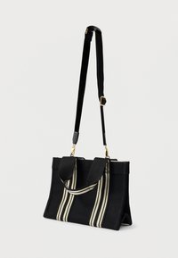 Borsa in tela nera con doppi manici, caratterizzata da strisce beige e bianche. Tracolla regolabile e dettagli in metallo dorato. Forma rettangolare.