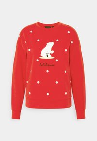 Sudadera roja con lunares blancos y un gráfico de un oso polar con el texto "que nieve". Tejido suave con un corte relajado y puños acanalados.