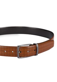 Bruine leren riem met een gestructureerd perforatiedesign, zilverkleurige metalen gesp en verstelbare gaten voor maatvoering. Zwarte voering aan de binnenkant.