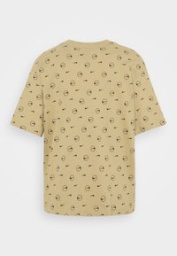 Krátký rukáv, khaki tričko vyrobené z jemné bavlny, s opakujícím se vzorem baseballových míčků a log Nike v černé barvě.