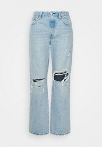 Jeans in denim blu chiaro con vestibilità rilassata, caratterizzati da dettagli strappati e ampie lacerazioni sulle ginocchia. Design classico a cinque tasche e chiusura con bottone.