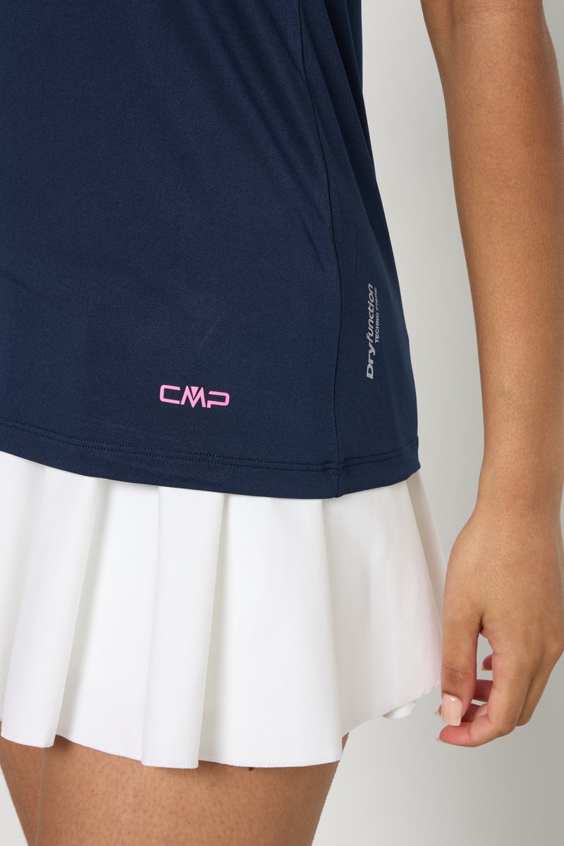 T-shirt de sport bleu marine en tissu anti-transpiration, avec un logo CMP rose au bas et une jupe plissée blanche.