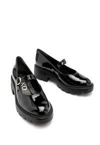Czarne lakierowane buty typu Mary Jane z okrągłym noskiem, regulowanym paskiem z metalowymi akcentami w kolorze srebrnym oraz masywną czarną platformą.