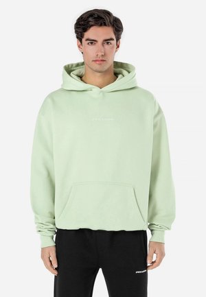 Light green hooded sweatshirt with a front pocket and ribbed cuffs. Features a small white logo on the chest. Made of soft fabric.