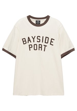 Krémszínű rövid ujjú póló sötétbarna szegéllyel a galléron és az ujjakon, elöl vastag, sötétbarna betűkkel "BAYSIDE PORT" felirattal.