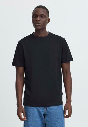 Tricou negru din bumbac, cu guler rotund și mâneci scurte. Dispune de un logo discret încadrat pe piept și o croială lejeră.