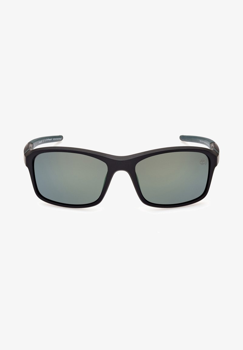Gafas de sol de plástico negro con montura rectangular y lentes tintados en verde. Superficie suave, sin hardware o acentos visibles.