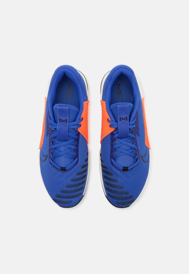Chaussures de sport bleues avec des accents orange, tige en mesh, design texturé noir, lacets plats et semelle rembourrée. Légères et respirantes.