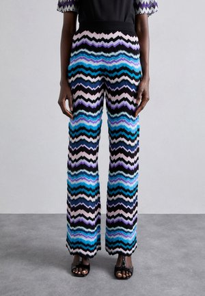 Multicolored wide-leg pants in a zigzag pattern featuring shades of blue, purple, black, and pink with a textured fabric and elastic waistband.