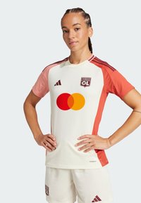Maillot de sport blanc avec des accents corail, présentant un col rond, une texture en maille, des détails logo et un grand symbole Mastercard rouge et jaune.
