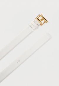 Λευκό λουράκι ρολογιού από δέρμα με αγκράφα από μεταλλικό υλικό σε χρυσό τόνο. Διαθέτει ομαλή υφή, μία γραμμή ραφής και μια τρύπα για προσαρμογή.