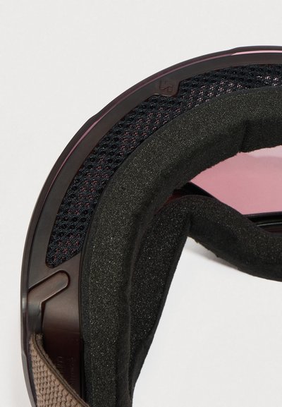 Rjava in črna športna čelada z teksturirano zunanjo lupino, oblazinjeno notranjostjo, mrežastimi poudarki in zatemnjenim vizirjem.