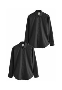 Chemises noires à manches longues, fabriquées dans un tissu doux, avec un col standard, une fermeture à boutons et un ourlet arrondi. Deux chemises sont exposées.