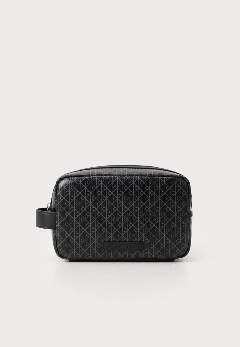 Zwarte cosmetica tas met een gestructureerd oppervlak met een geometrisch patroon. Inclusief een zijhandvat en logo detail aan de voorkant.