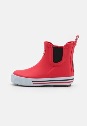 Bota de lluvia roja de caña baja con panel lateral elástico negro, suela de goma blanca con rayas negras y rojas, y tira en la parte trasera.