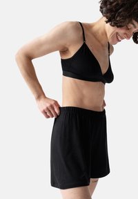 Zwarte katoenen bralette met verstelbare bandjes en bijpassende zwarte elastische taillebandshorts. Comfortabele, casual pasvorm, minimalistisch ontwerp.