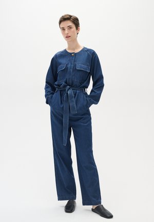 Dunkelblauer Denim-Overall mit langen Ärmeln, zwei Brusttaschen, Knopfverschluss auf der Vorderseite und einem gebundenen Taillengürtel, der eine lockere Passform bietet.