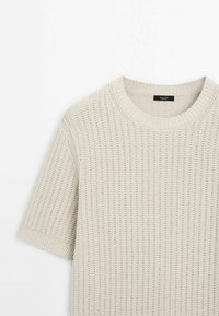 Light beige knitted short-sleeve sweater featuring a ribbed crew neckline and textured stitch pattern. Soft, breathable fabric.