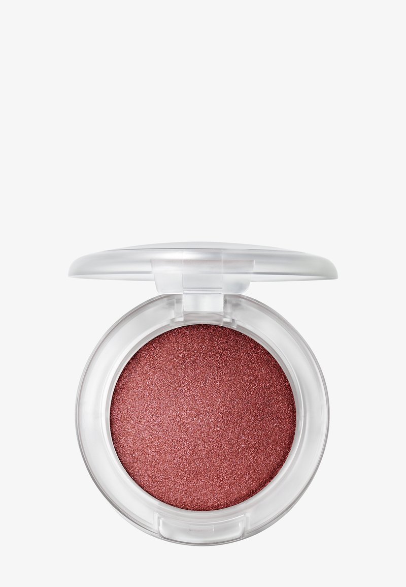 Ombre à paupières rose scintillante dans un compact rond et transparent avec le couvercle ouvert sur un fond blanc.