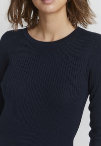 Granatowy sweter ribbed knit z okrągłym dekoltem i teksturą w pionowe paski. Dopasowany, z długimi rękawami, wykonany z miękkiego materiału, z bezszwowym wykończeniem.