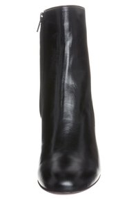 Černá kotníková bota z hladké kůže, se zipem vzadu a zaoblenou špičkou. Elegantní design bez viditelných vzorů či zdobení.