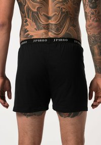 Zwarte katoenen boxershorts met een elastische tailleband waarop de tekst "JP1880" in het wit is gedrukt. Het ontwerp heeft een gladde textuur en een aansluitende pasvorm.