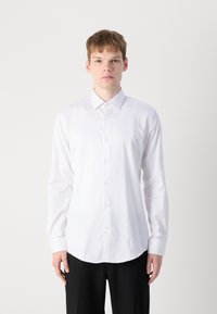 White long-sleeve button-up shirt with a crisp collar. Textured fabric features subtle herringbone pattern. Rounded hem and standard cuffs.