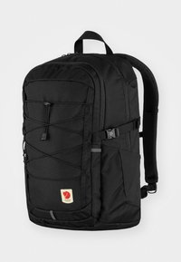 Black fabric backpack with a rectangular shape, featuring a front bungee cord, zipper pockets, padded straps, and a logo patch.