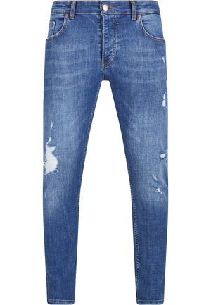 Blugi din denim albastru cu o croială slim, având detalii uzate și petice desfăcute pe coapse. Design clasic cu cinci buzunare și cusături subtile.