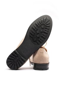 Scarpe in camoscio beige con suola in gomma nera, caratterizzate da un motivo scanalato sulla suola, lacci e design minimalista. Taglia 37 indicata all'interno.