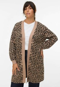 Cardigan à motifs léopard en beige et noir, doté d'une bordure texturée contrastante marron et de poignets côtelés. Matière en laine douce.