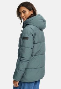 Padded teal jacket with a hood, featuring a branded patch on the sleeve, elastic drawstrings, and a quilted texture.