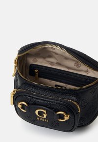 Schwarze strukturierte Tasche mit goldenen Beschlägen, ausgestattet mit einem Reißverschluss. Das Innere hat eine beige Fütterung mit Logo-Mustern und einem Reißverschlussfach.