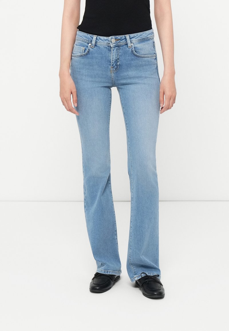 Light blue denim flared jeans with a mid-rise waist, five-pocket design, belt loops, and subtle whiskering details at the front.