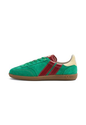 Baskets en suède vert avec deux bandes en cuir rouge, languette de talon beige et semelle en caoutchouc naturel, vues de côté.