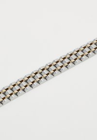 Bracelet en métal composé de maillons alternés en argent et en or, avec des formes arrondies et une texture lisse, réfléchissant la lumière.