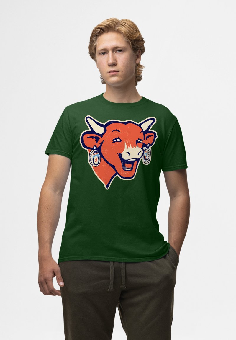 Zelené bavlněné tričko s potiskem usmívající se oranžové krávy s bílými rohy a náušnicemi, zobrazené ve frontálním pohledu.