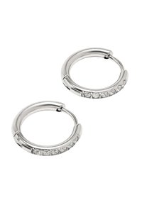 Srebrne metalowe kolczyki w kształcie kółek z wypolerowaną powierzchnią, ozdobione rzędem małych, przezroczystych kryształków wzdłuż dolnej krawędzi. Okrągły design.