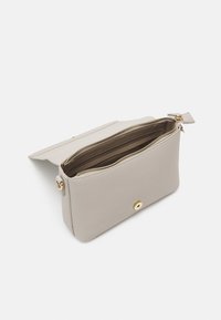 Light grey leather purse with a zipper top, gold hardware detail, and interior compartments. Flap closure with a circular gold accent.