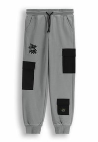 Szare dresowe spodnie z czarnymi kieszeniami cargo, elastycznym pasem ze sznurkiem i nadrukowanym logo na lewym nogawce.