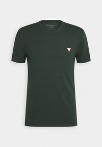 T-shirt à manches courtes, col rond, de couleur vert foncé, avec un petit logo triangulaire rouge et blanc sur le côté gauche de la poitrine.